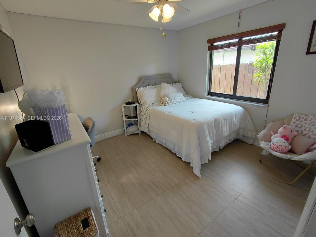 15630 Southwest 146th Avenue Miami, FL 33177 - Photo 21 of 23 a bedroom with a bed and a chandelier