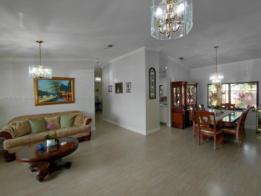 15630 Southwest 146th Avenue Miami, FL 33177 - Photo 3 of 23 a living room with furniture and a chandelier