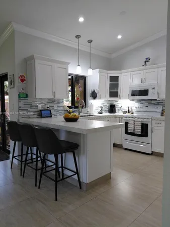 a kitchen with a sink cabinets and wooden floor