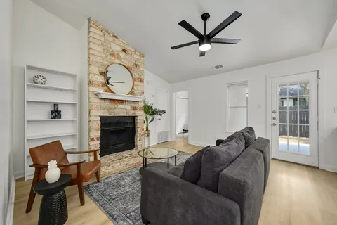 a living room with furniture a fireplace and wooden floor