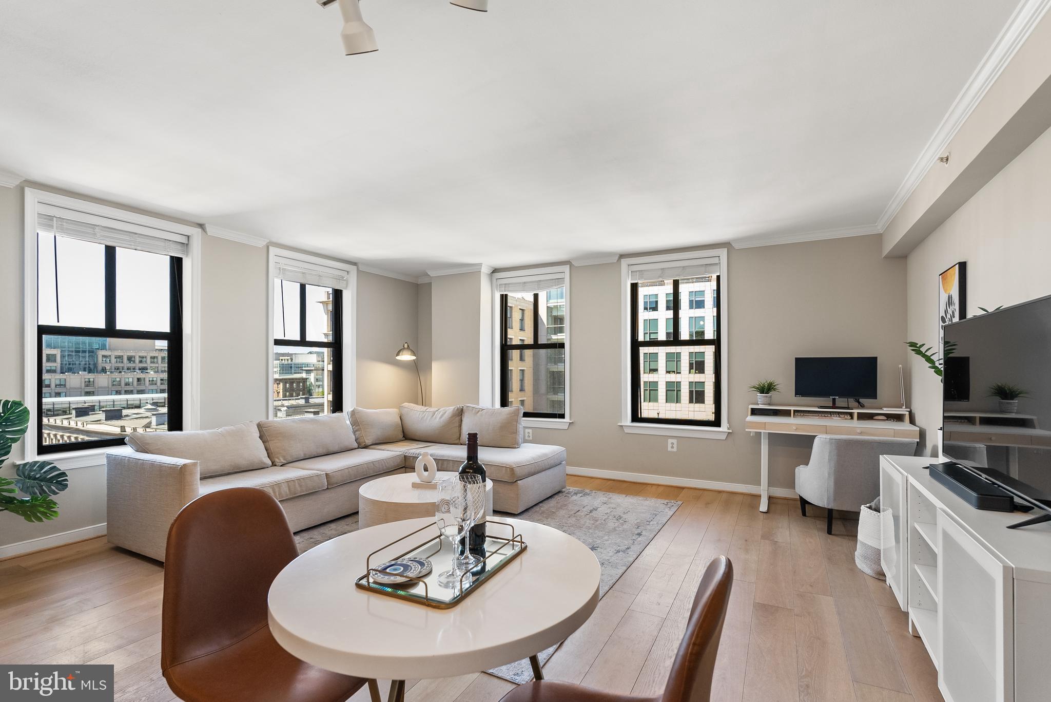a living room with furniture flat screen tv and window