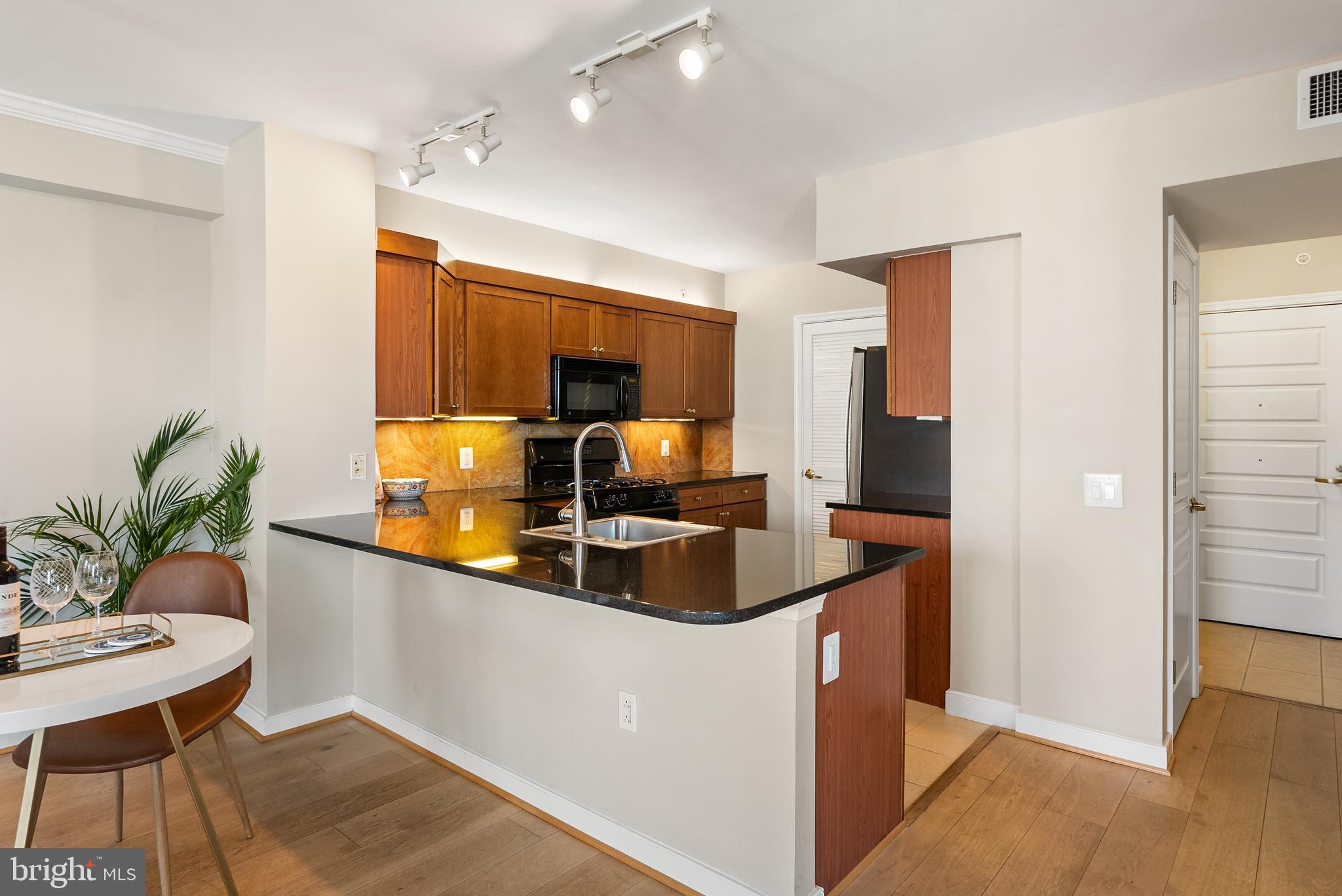 616 E Street Northwest, Unit 1019 Washington, DC 20004 - Photo 6 of 21 a kitchen with granite countertop a sink and a refrigerator