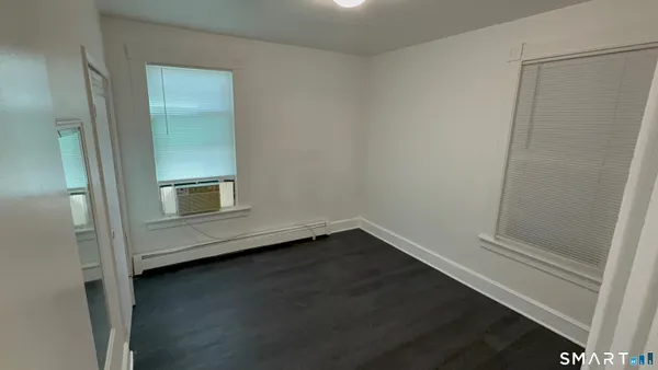 a view of a small space with wooden floor and a window