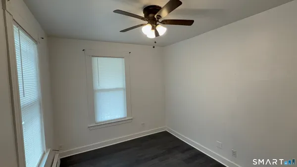 a view of a workspace with wooden floor and a window