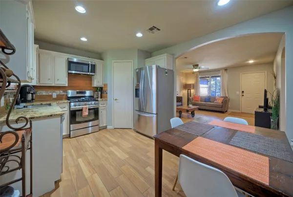 a large kitchen with kitchen island a large counter top space a sink stainless steel appliances and cabinets
