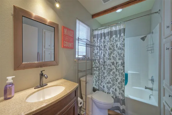 a bathroom with a granite countertop sink toilet and shower