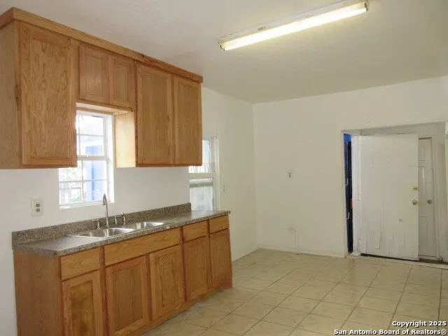 a kitchen with granite countertop a sink cabinets and a window