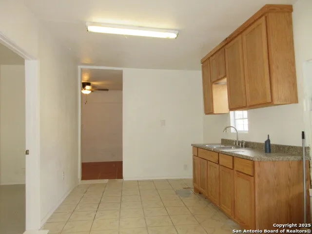 a kitchen with a sink a refrigerator and cabinets