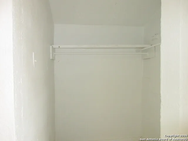 a view of a room with a ceiling fan and a carpet