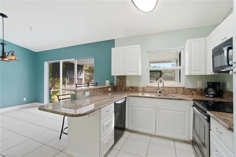 a kitchen with stainless steel appliances granite countertop a sink stove and cabinets