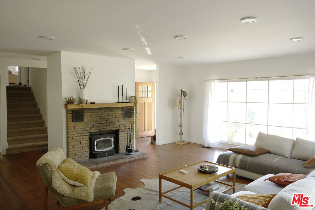 53505 Tollgate Road Idyllwild, CA 92549 - Photo 6 of 42 a living room with furniture a fireplace and a large window