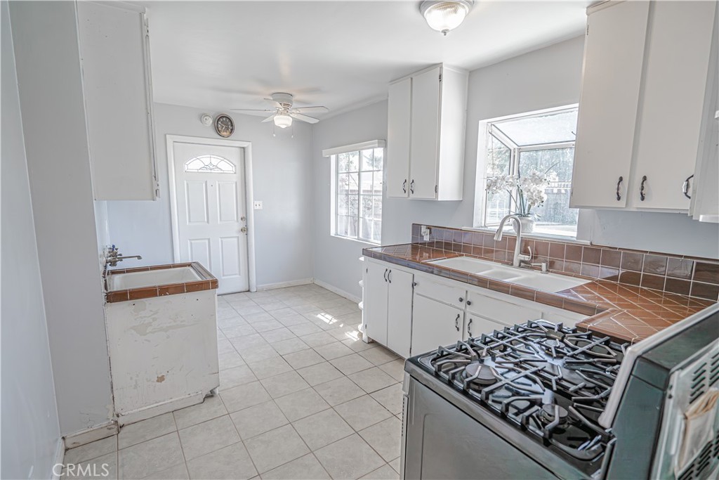 150 East 233rd Street Carson, CA 90745 - Photo 9 of 22 a kitchen with granite countertop a sink stove and cabinets
