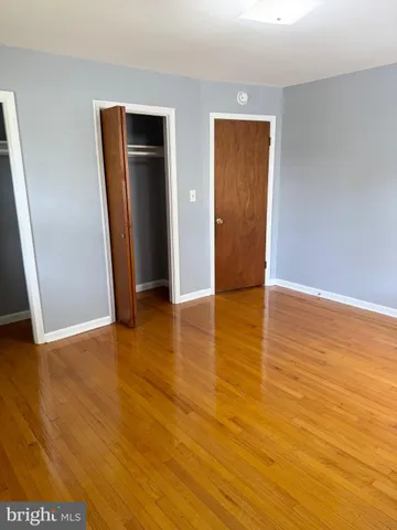 an empty room with wooden floor and closet