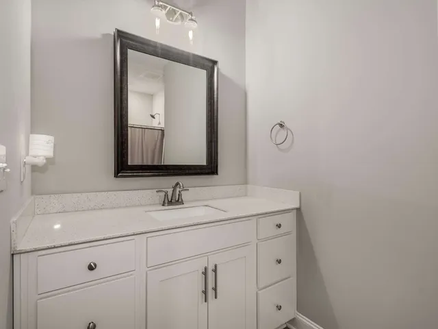 a bathroom with a sink vanity and mirror