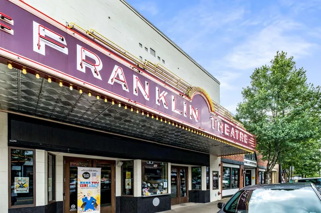 a front view of multi story building with retail shops