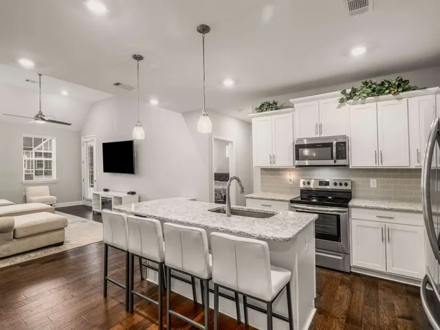 a kitchen with stainless steel appliances granite countertop a stove a sink a microwave a center island and furniture