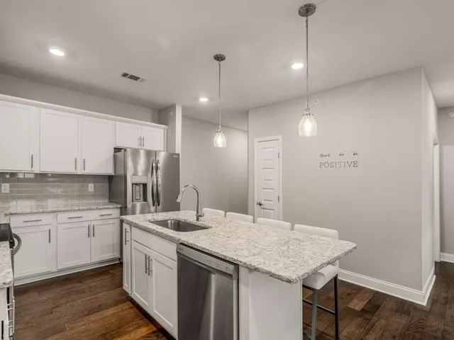 a kitchen with a sink a refrigerator and cabinets