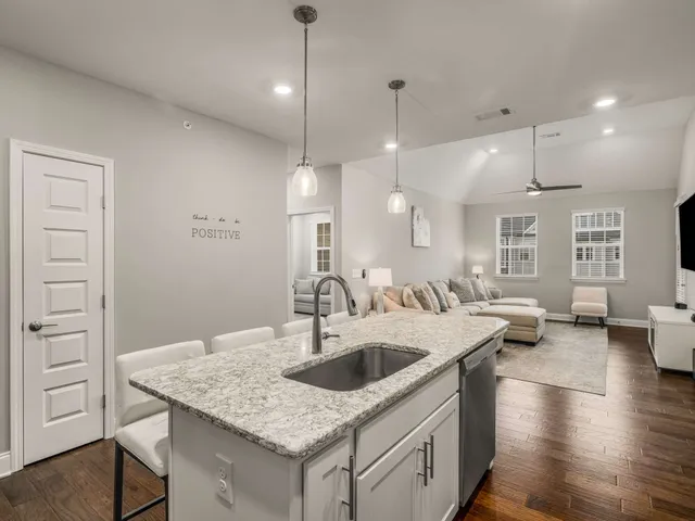a kitchen with a sink a center island a counter space and living room view