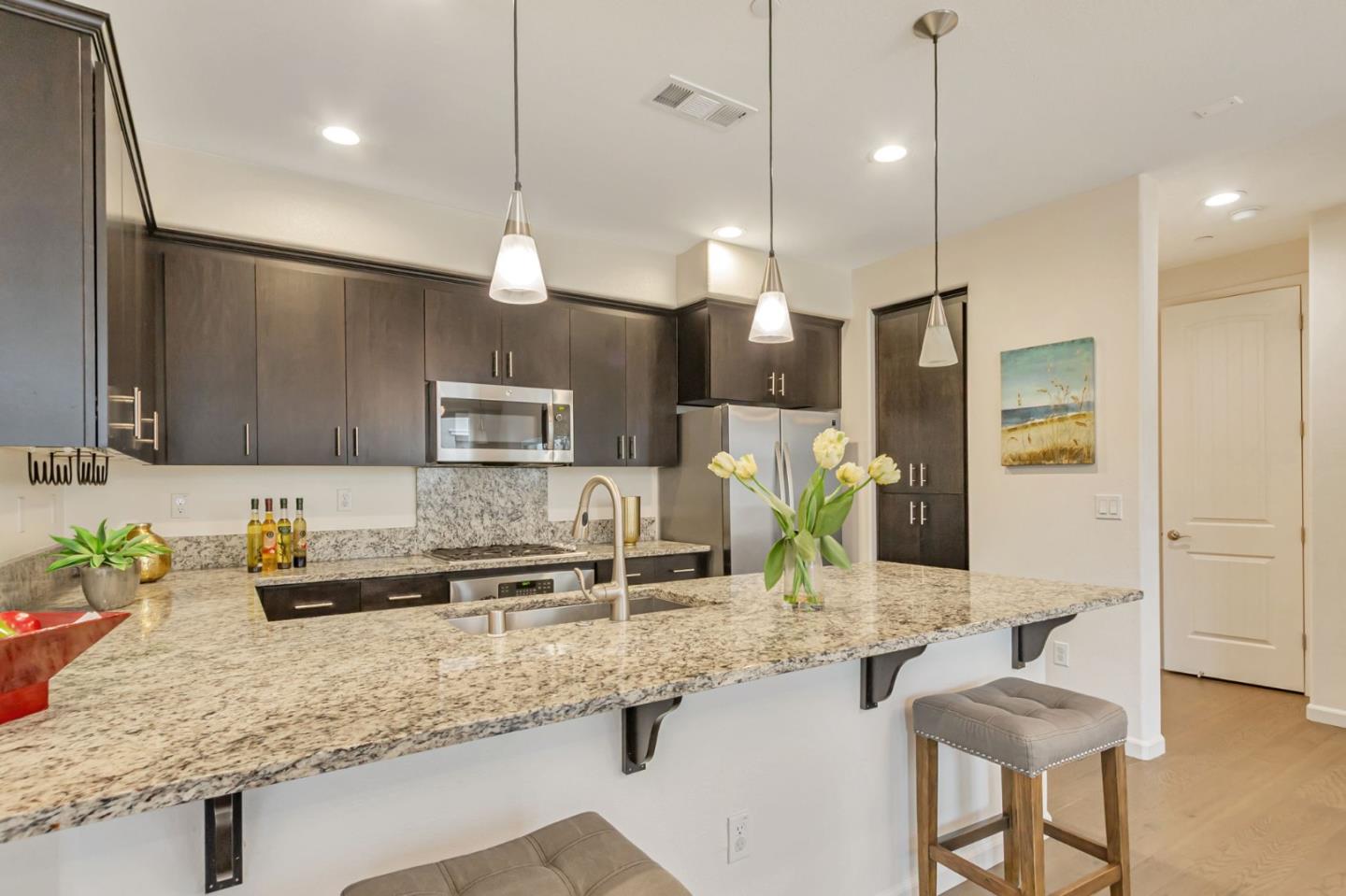 1890 Trento Loop Milpitas, CA 95035 - Photo 6 of 39 a kitchen with kitchen island granite countertop a sink and chairs
