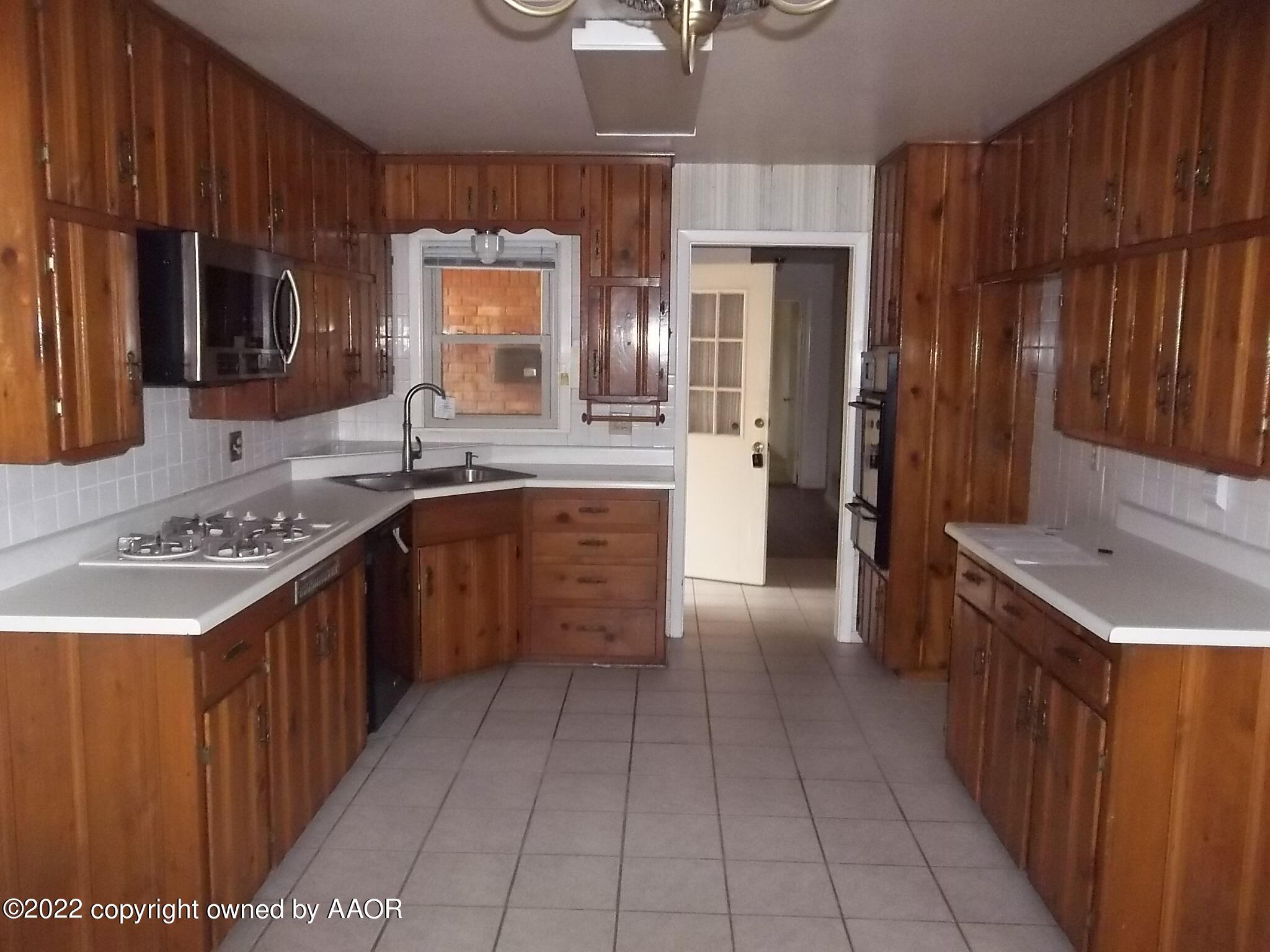 4010 Tucson Drive Amarillo, TX 79109 - Photo 11 of 23 a kitchen with a sink stove top oven and cabinets