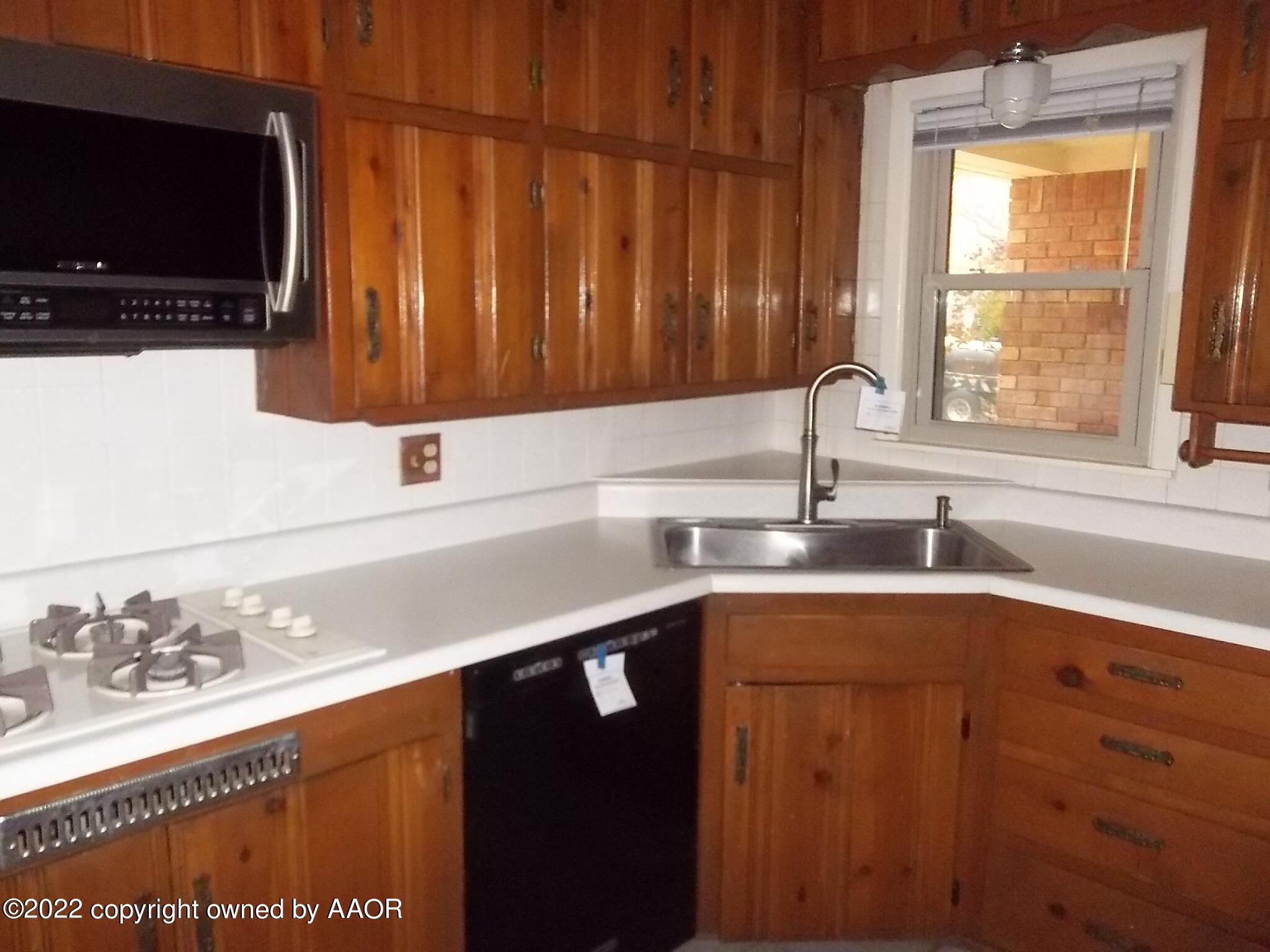4010 Tucson Drive Amarillo, TX 79109 - Photo 12 of 23 a kitchen with a sink a window and a microwave