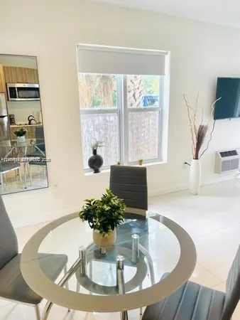 a dining room with furniture and a large window