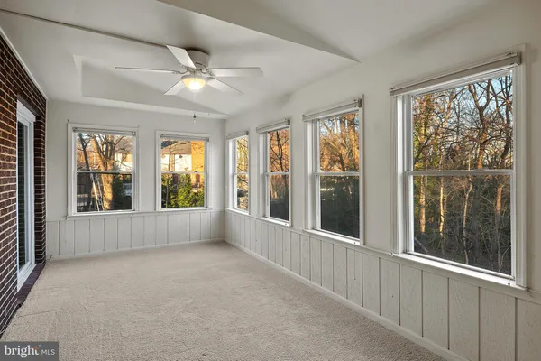 an empty room with wooden floor fireplace and windows