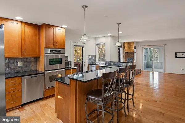 a kitchen with stainless steel appliances a dining table chairs and granite counter tops