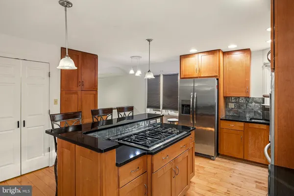 a kitchen with stainless steel appliances a dining table chairs stove and sink