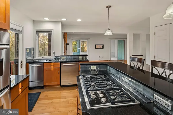 a kitchen island a stove a refrigerator and wooden floor