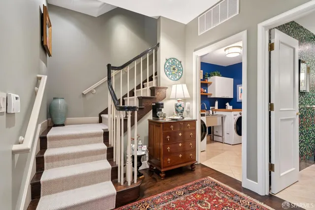 a living room with furniture cabinets and wooden floor