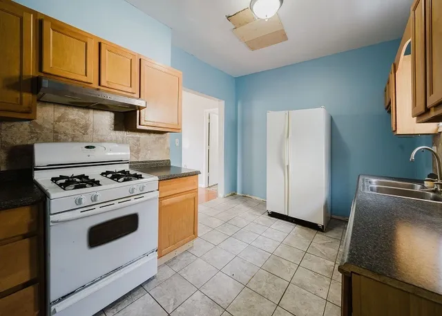 a kitchen with a refrigerator and a stove top oven