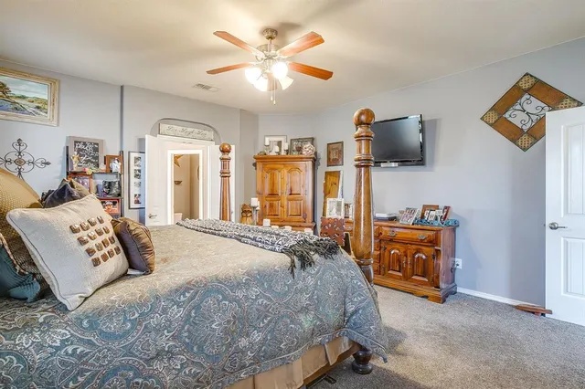 a bedroom with large bed and a chandelier