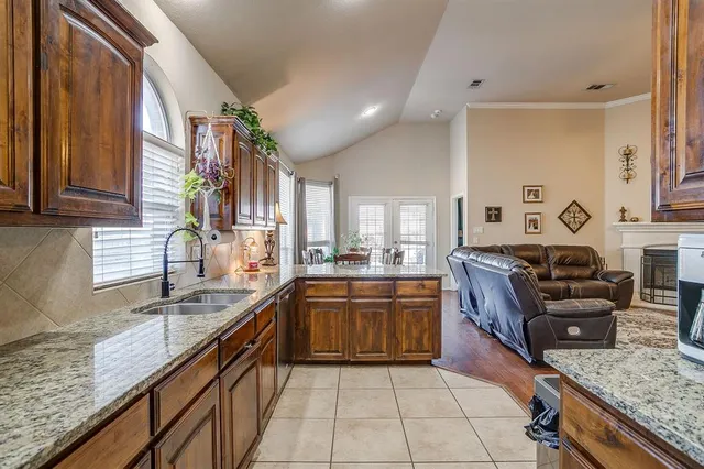 a large kitchen with granite countertop a sink dishwasher stove and cabinets