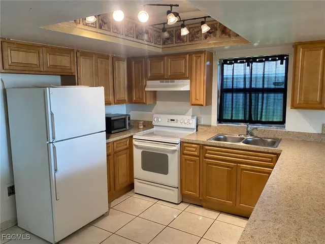 a kitchen with a refrigerator sink and cabinets