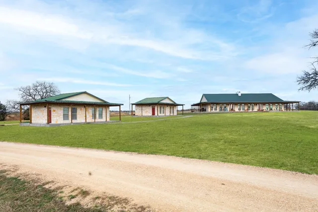 a view of a house with a big yard and large trees