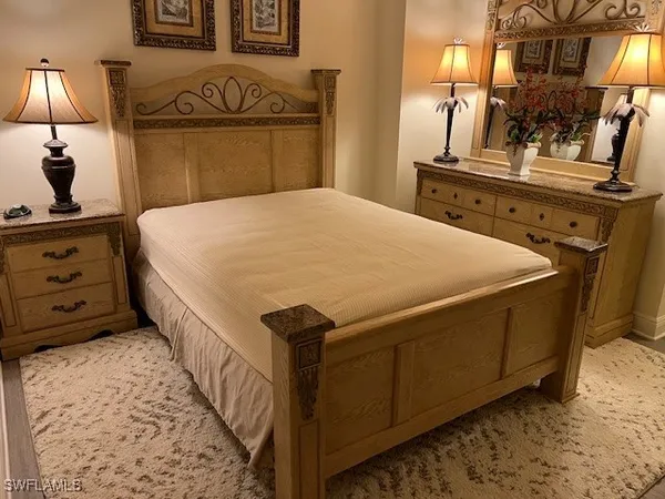 a bedroom with a bed and a mirror on dresser
