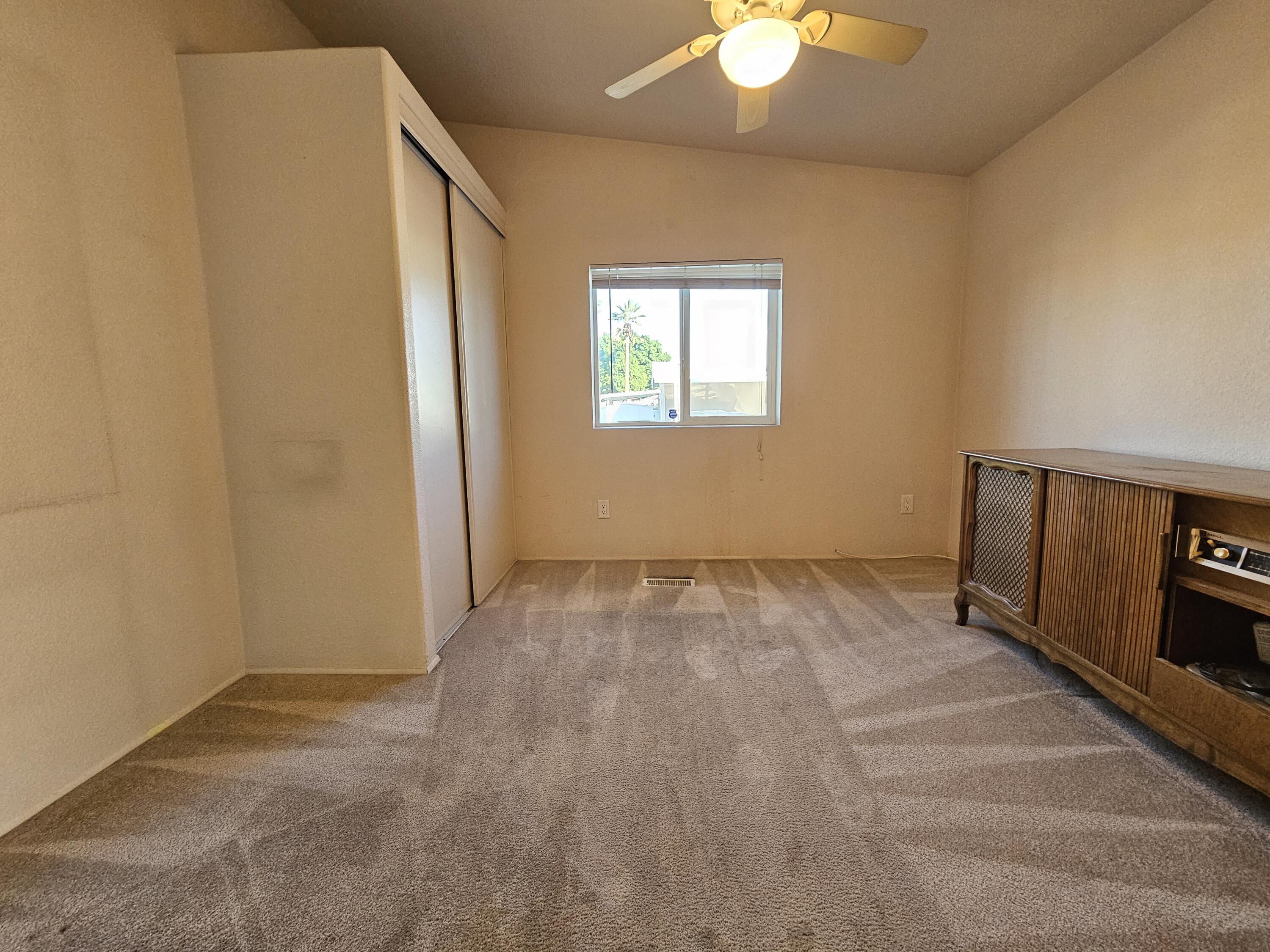 51 Alesandro Road Palm Springs, CA 92264 - Photo 11 of 21 an empty room with a chandelier fan and windows