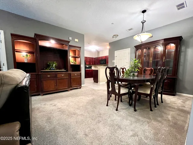 a view of a dining room with furniture and chandelier