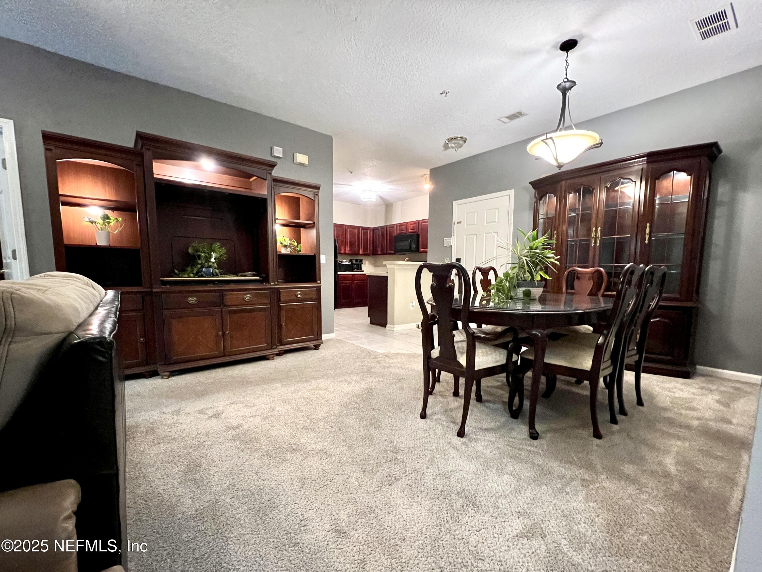 3610 Kirkpatrick Circle, Unit 8 Jacksonville, FL 32210 - Photo 13 of 18 a view of a dining room with furniture and chandelier