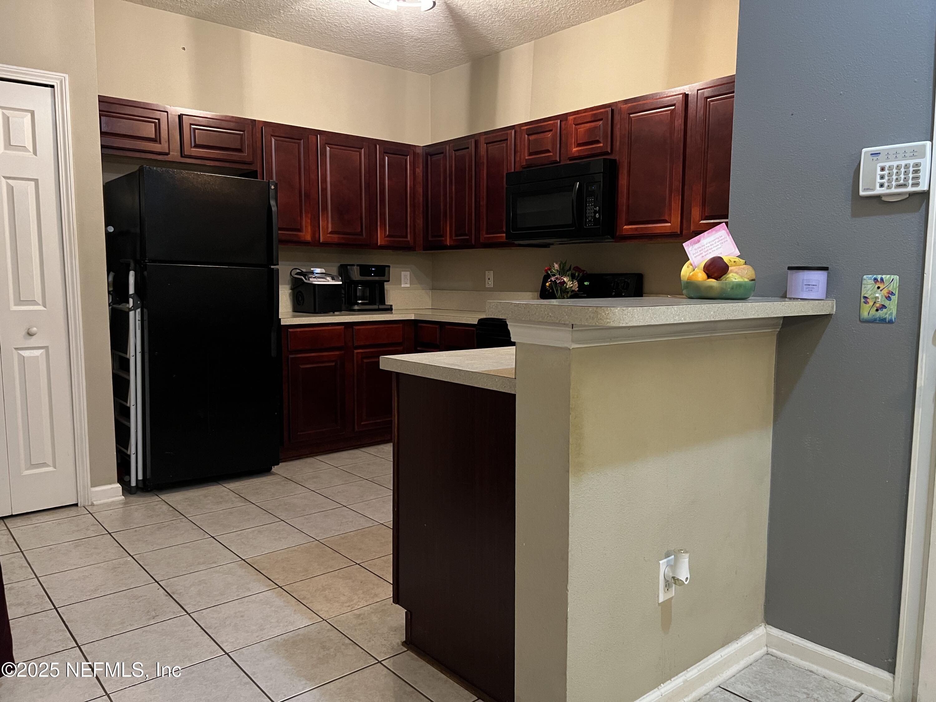 3610 Kirkpatrick Circle, Unit 8 Jacksonville, FL 32210 - Photo 2 of 18 a kitchen with a refrigerator and a microwave