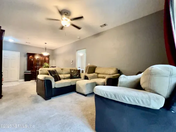 a living room with furniture and a ceiling fan