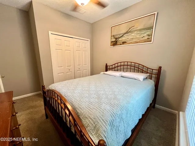 a bedroom with a bed and painting on the wall