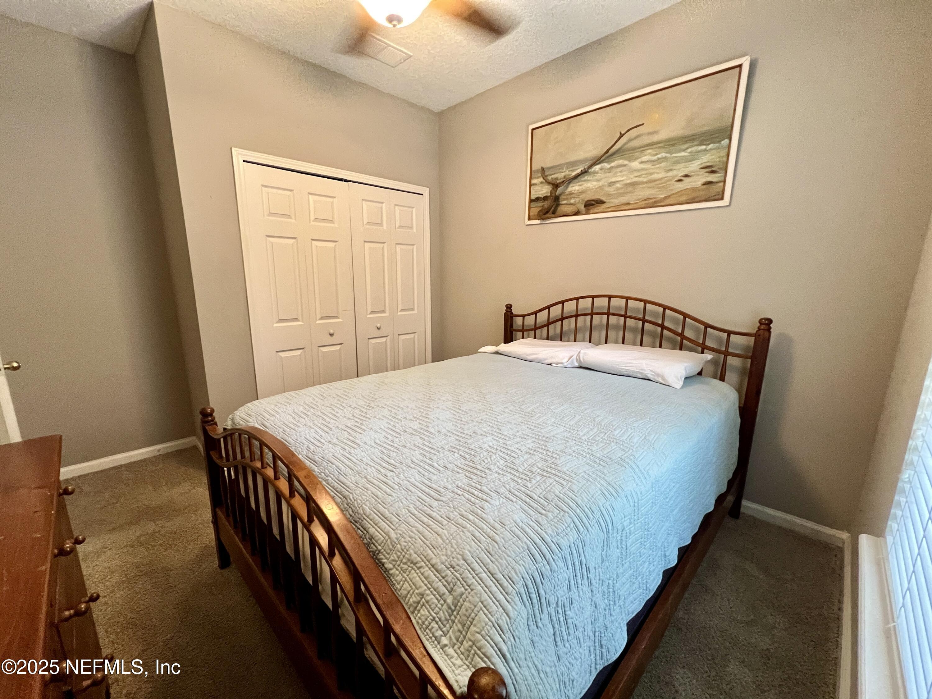 3610 Kirkpatrick Circle, Unit 8 Jacksonville, FL 32210 - Photo 6 of 18 a bedroom with a bed and painting on the wall
