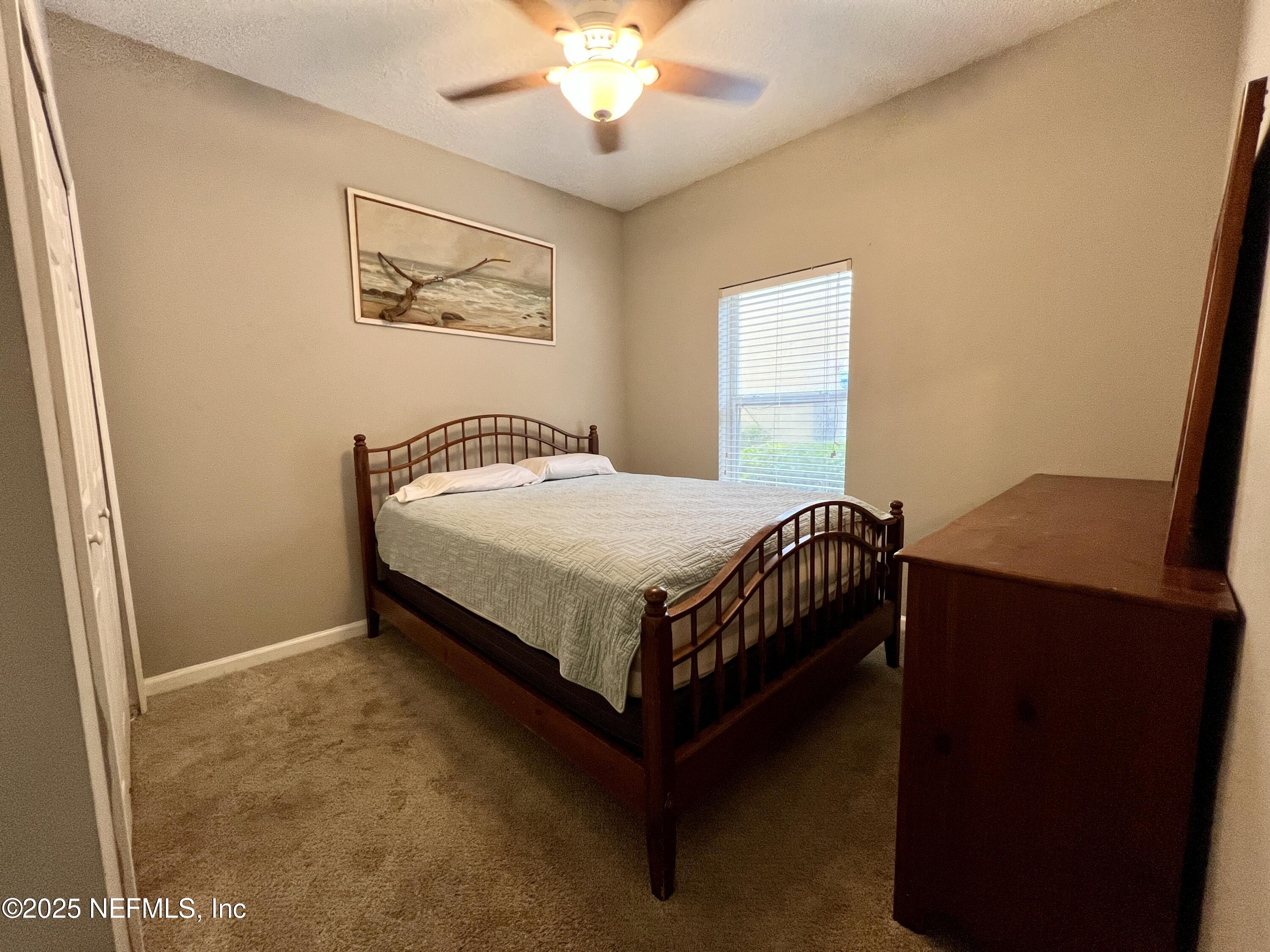 3610 Kirkpatrick Circle, Unit 8 Jacksonville, FL 32210 - Photo 8 of 18 a bedroom with a bed and a chandelier