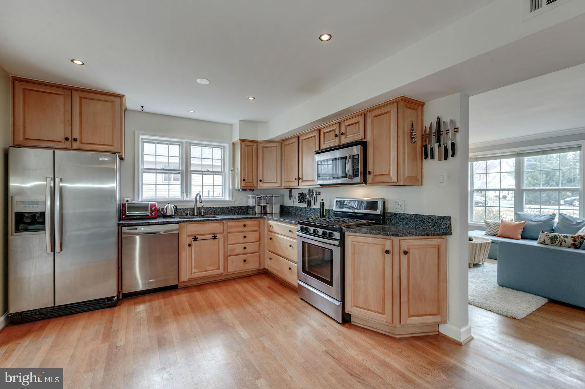 7004 Ridgeway Drive Springfield, VA 22150 - Photo 12 of 28 a large kitchen with stainless steel appliances granite countertop a stove a sink dishwasher a microwave oven and a refrigerator with wooden floor