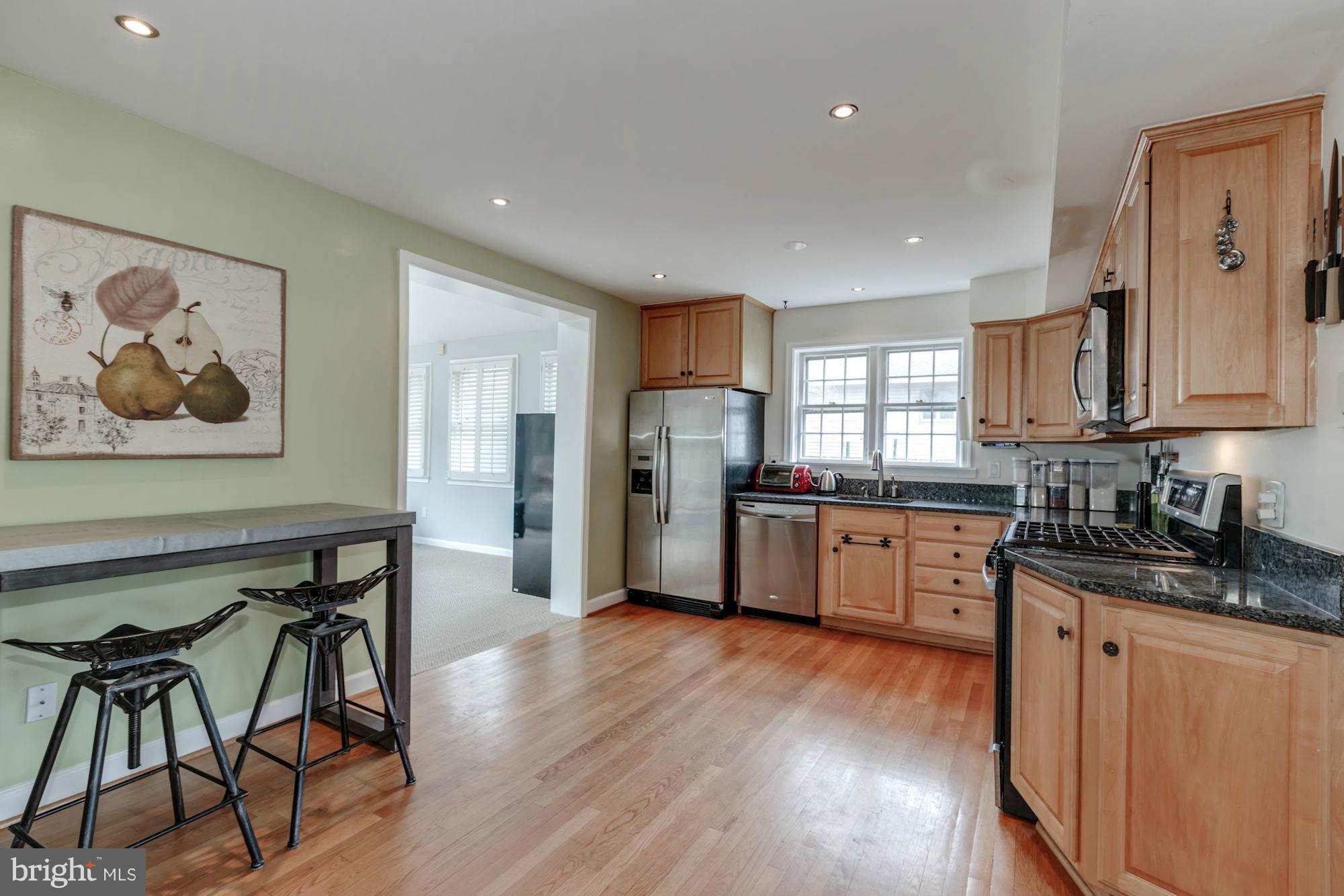 7004 Ridgeway Drive Springfield, VA 22150 - Photo 13 of 28 a kitchen with stainless steel appliances wooden floors and white cabinets