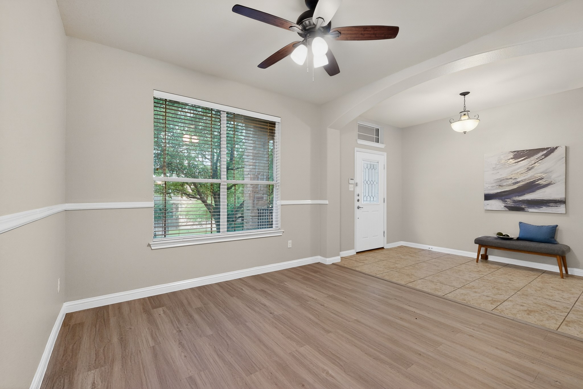 178 Limestone Trail Austin, TX 78737 - Photo 6 of 40 Spacious interior featuring wood-finish flooring, a ceiling fan with integrated lighting, a large window with horizontal blinds, and a white paneled entrance door with decorative glass inserts