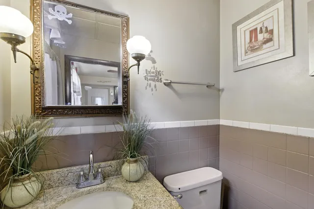 a bathroom with a granite countertop sink mirror and toilet