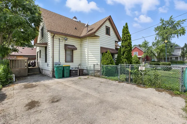 a view of a house with a small yard and palm trees